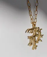 Collar con cordón de cuero negro y dije plateado con forma de coral con incrustaciones de piedras celestes.