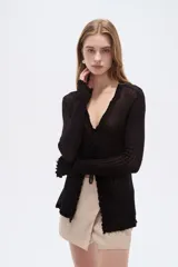 Saco abierto de viscosa color blanco, con cuello en V, lazo para anudar al frente y mangas largas con terminación ondulada.