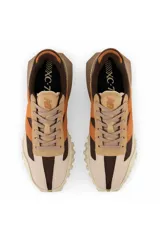 Championes urbanos New Balance modelo XC-72, con diseño de paneles en tonos beige, marrón y naranja. Presentan una suela de goma texturizada con diseño dividido y logo N en el lateral.
