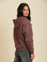 Canguro con cierre color gris topo, con capucha y logo bordado en el pecho.