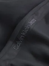 Buzo negro de poliéster con cuello redondo, puños y dobladillo con punto canalé, corte relaxed y cinta decorativa con el logo de la marca en los laterales.