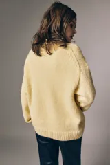 Sweater de punto suave color amarillo, con cuello redondo, hombros caídos y diseño de corte clásico.