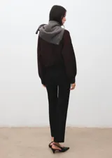 Pantalón negro de vestir, de corte recto y tiro medio, con trabillas para cinturón y bolsillos.
