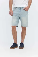 Bermuda de denim de corte relaxed, color celeste claro con efecto deslavado y sutiles roturas en los bolsillos. Diseño de tiro medio, bolsillos clásicos y cierre frontal con botón y cremallera.