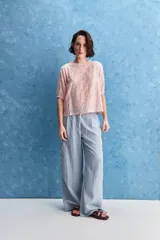 Blusa de manga corta color rosado con estampa orgánica de inspiración floral, cuello redondo y ajuste mediante lazo en el ruedo.
