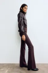 Pantalón ajustado de punto fino en color bordó, de tiro alto con elástico revestido en la cintura y diseño de piernas acampanadas.