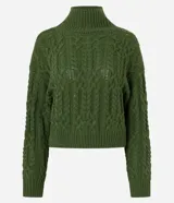 Suéter de punto color verde oliva con diseño de trenzas, cuello alto y mangas largas. Presenta un corte corto con terminaciones acanaladas en puños, cuello y ruedo.