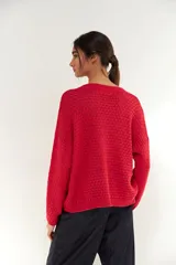 Sweater de punto con textura tipo esterilla, color rojo, con escote en V y mangas largas con puños acanalados.