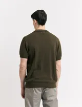 Remera color café de tejido de punto, con cuello polo y mangas cortas.