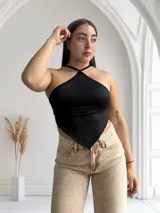 Top negro con tirantes finos que se cruzan en la espalda y terminan en un lazo.