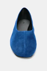 Zapato tipo bailarina de ante en color azul, con acabado en punta redonda y suela plana.