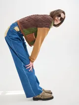 Pantalón jean de tiro alto y corte pinzado, con perneras de caída suelta y levemente anchas en el bajo. Posee pasador con hebilla en la parte trasera.