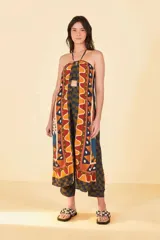 Mono largo con estampado abstracto en tonos marrones, azules y naranjas. Presenta escote halter con abertura en el abdomen y pantalón palazzo.