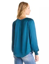 Blusa de satén color verde azulado con acabado sedoso y fluido. Escote a la base con frunce perimetral, mangas largas estilo balloon con detalle de punto smock en hombros y puños. Espalda con abertura tipo gota y botón forrado a tono.