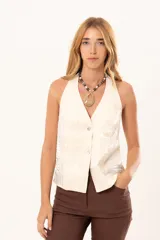 Chaleco de corte sastrero color manteca, con escote en V, cierre frontal con botones nacarados y acabado satinado con textura sutil.