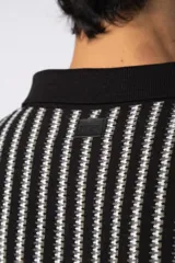 Chomba de tejido de punto con diseño de rayas verticales en tonos beige y marrón, cuello polo y mangas cortas con terminación acanalada.