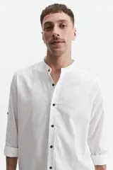 Camisa blanca de lino para hombre, de mangas largas con puños abotonados, cuello mao y cierre frontal con botones de madera. Corte recto.