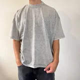 Remera de corte boxy fit con efecto de lavado ácido (snow wash) en color gris, cuello redondo y mangas cortas.
