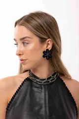 Aro en forma de flor de color negro con diseño central de glitter plateado.