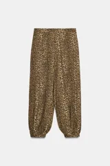 Pantalón bombacho de tiro medio con estampado animal print, bolsillos delanteros, bajo con puño y cierre frontal con cremallera y gancho metálico.