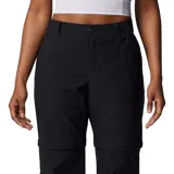 Pantalón técnico convertible en short, color negro, con diseño funcional para actividades al aire libre. Presenta rodillas articuladas, múltiples bolsillos incluyendo uno de seguridad con cierre, presillas para cinturón y dobladillo ajustable. Las piernas son desmontables mediante cierres diferenciados.