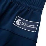 Short de fútbol azul marino con detalles en azul eléctrico y escudo del Real Madrid bordado en la pierna derecha.