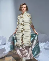 Bufandón de lana merino afieltrada color natural, formado por piezas horizontales unidas que generan una textura continua.