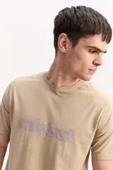 Remera de algodón color beige, de manga corta y cuello redondo, con logo estampado en el pecho en tono morado.