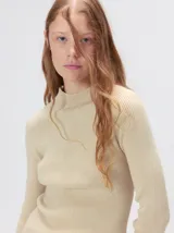 Remera de cuello alto tipo polera, confeccionada en tela rib con textura acanalada y ajuste al cuerpo. Presenta mangas largas y un pequeño bordado distintivo en la parte inferior.