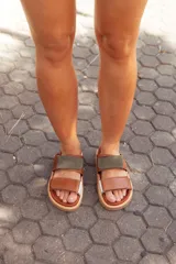 Sandalias de cuero color marrón con detalles en verde y blanco, con ajuste de velcro.