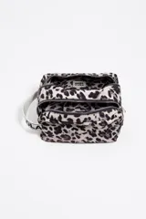 Neceser de gran tamaño con exterior de nylon estampado animal print (leopardo) en tonos rosa fuerte y negro. Presenta estructura soft, cierre con cremallera, logo metálico BIMBA Y LOLA y bolsillo interior. Incluye una etiqueta de tejido con el nombre de la marca y una correa lateral de tela blanca con texto negro.
