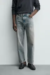 Jeans de corte recto y tiro medio confeccionados en denim de algodón con efecto lavado, diseño de cinco bolsillos y cierre frontal con cremallera y botón.