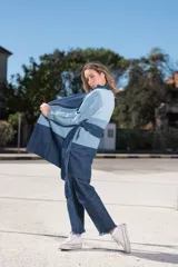 Tapado de jean con diseño color block en dos tonos de azul, con cuello solapa y lazo para atar en la cintura.