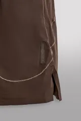 Short de running color marrón, confeccionado en tejido técnico elástico con forro interior. Cuenta con cintura elástica ajustable, bolsillos laterales con cierre de cremallera oculto y aberturas en las perneras.