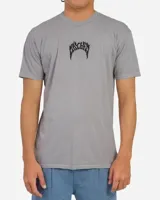Remera de manga corta color gris con efecto vintage dye, cuello redondo y estampa frontal pequeña en el centro con la inscripción de la marca en tipografía gótica.