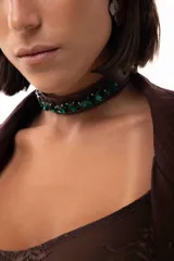 Gargantilla tipo choker de simil cuero marrón con medallones facetados en color verde esmeralda bordados. Cuenta con cadena de acero quirúrgico para ajuste.