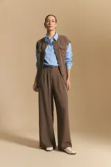 Pantalón ancho color marrón, de silueta moderna y calce cómodo, con diseño limpio y fluido. Presenta cierre frontal con botón y cordones ajustables en la cintura.