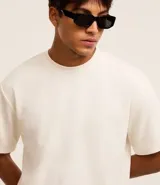 Remera masculina color blanco hueso, modelo boxy, con cuello redondo y mangas cortas. Confeccionada con tecnología Dry para un tacto frío en el interior y algodón en el exterior.