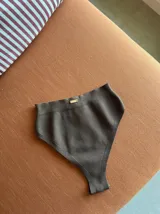 Conjunto de bikini negro de hilo, con corpiño bandeau y bombacha vedetina de tiro alto.