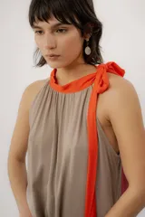 Vestido largo color marrón con detalles en tono marfil, escote halter y lazo largo en el cuello.
