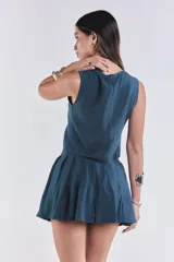 Chaleco azul petróleo con escote en V y lazo ajustable en el frente.