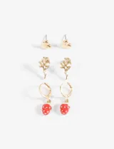 Set de caravanas doradas con tres pares de aros: un par de aros tipo botón con forma de corazón, un par de aros colgantes con forma de rosa y un par de aros tipo argolla con dije de frutilla esmaltada en rojo.
