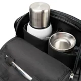 Bolso matero de diseño vertical en color negro, confeccionado en material texturizado símil cuero. Cuenta con doble asa superior, correa ajustable y extraíble para llevar al hombro, y cierre principal. Incluye un aplique metálico con el logo de la marca en el frente.