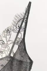 Top de punto acanalado con escote en pico y delicada aplicación de encaje floral a tono en el escote y espalda. Presenta tirantes finos y un corte ajustado al cuerpo.