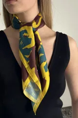 Pañuelo cuadrado de satén con estampado abstracto en tonos marrón, amarillo y verde azulado.