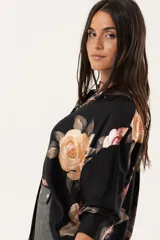 Camisa oversize negra con estampado floral, abotonada y con cuello camisero.
