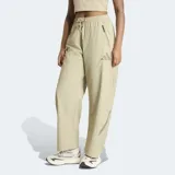 Pantalon Adidas Z.N.E. de corte holgado, confeccionado en tejido ripstop color beige. Presenta cintura elástica con cordón de ajuste, bolsillos laterales con cierre y detalles de estampado en caucho mate.