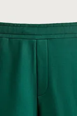 Pantalón jogger de corte relajado y pernera ancha, confeccionado en tejido de algodón con interior perchado. Cuenta con cintura elástica ajustable mediante cordón interior, bolsillos laterales y un bolsillo trasero de plastrón.
