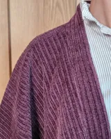 Ruana abierta de tejido de punto acanalado en color beige, con diseño holgado y caída fluida.