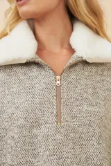 Poncho color crema con cuello de corderito desmontable y cierre dorado.